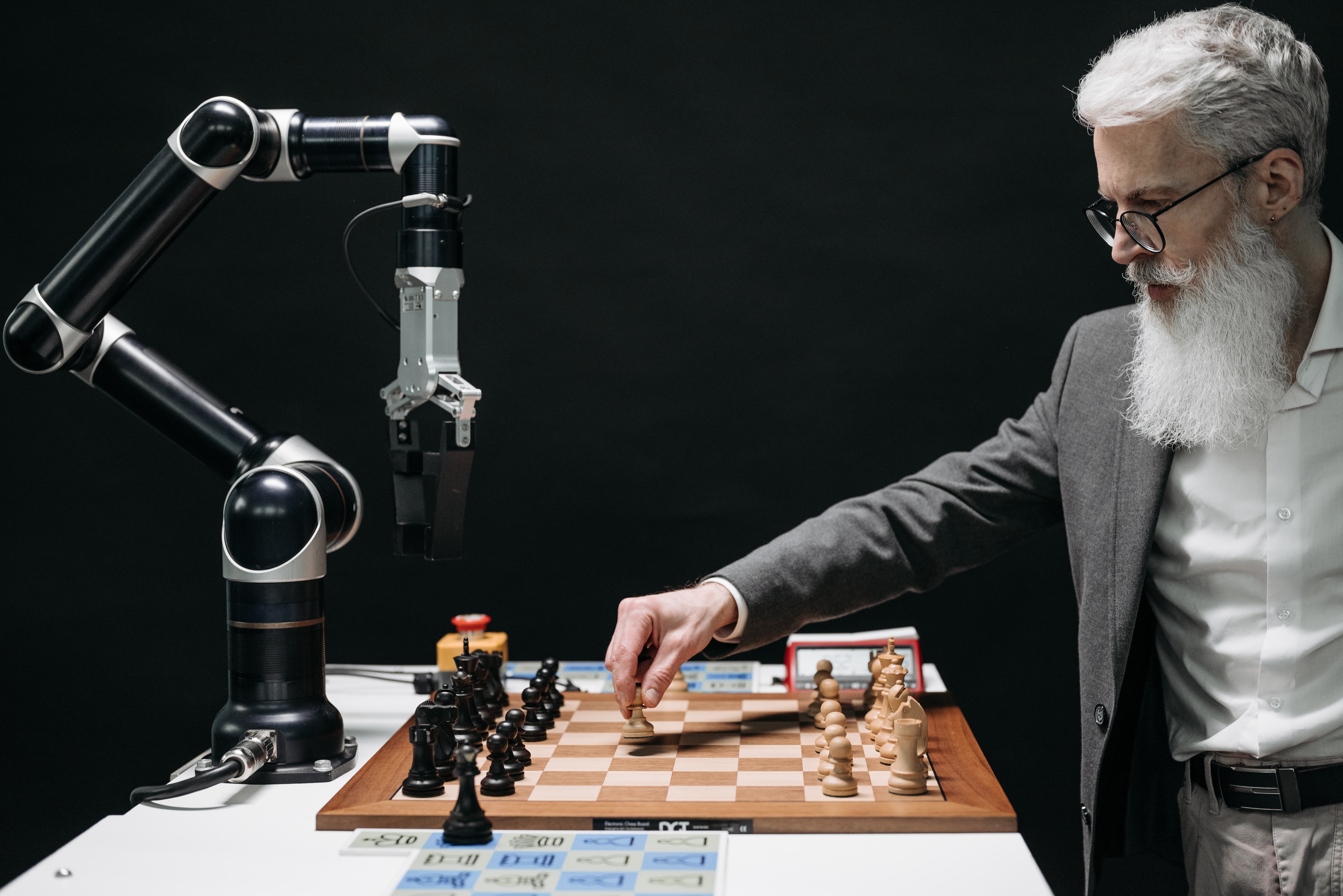 older philosopher looking man playing chess against AI robot